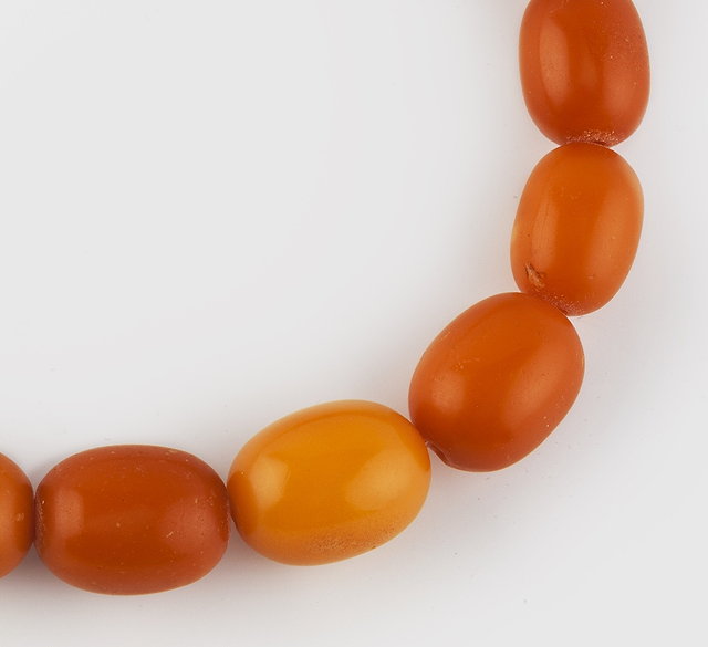 Appraisal: A GRADUATED AMBER BEAD NECKLACE comprising a single strand of