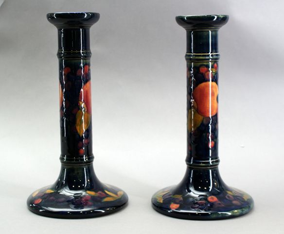 Appraisal: A pair of candlesticks decorated in the pomegranate design Designed