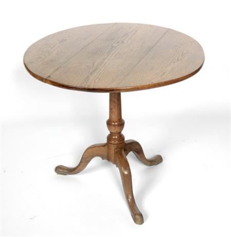 Appraisal: A circular oak tea table raised on urn shaped tapering