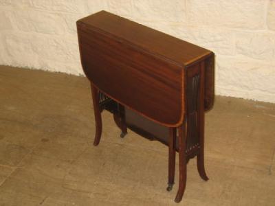 Appraisal: AN EDWARDIAN MAHOGANY SUTHERLAND TABLE of rounded oblong form crossbanded