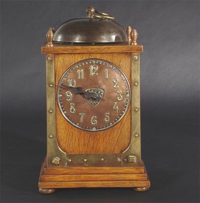 Appraisal: A Continental oak and mixed metal mantel clock in the