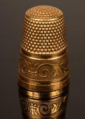 Appraisal: A gold thimble with engraved borders size cm high