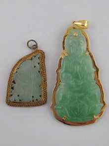 Appraisal: Two Chinese carved jade pendants one gold mounted the other