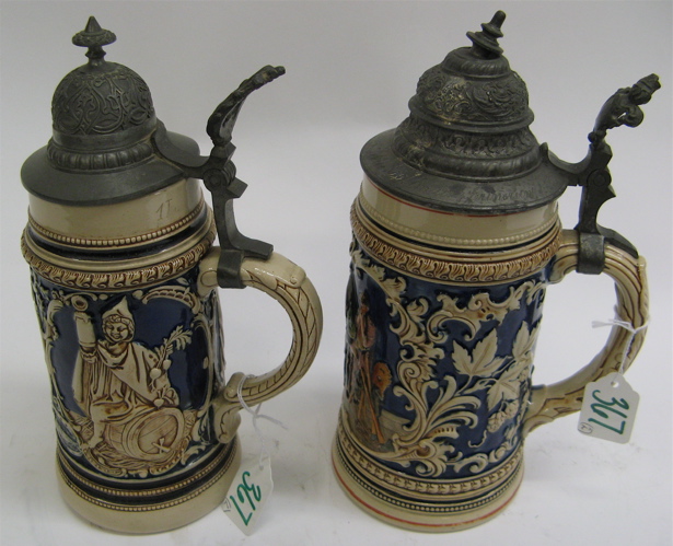 Appraisal: TWO GERMAN STONEWARE POTTERY BEER STEINS L size colorful drinking