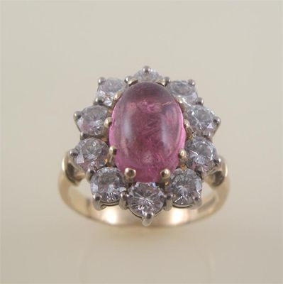 Appraisal: An oval shaped cabochon pink stone and diamond cluster ring