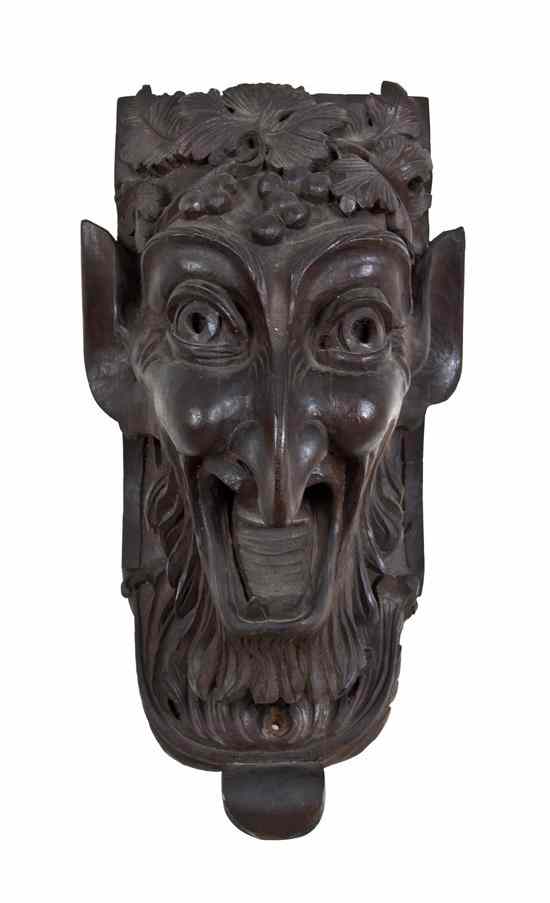 Appraisal: An Austrian Carved Wood Mask Fragment depicting a Bacchic grotesque