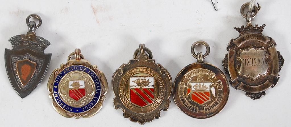 Appraisal: THREE RUSHOLME DISTRICT AMATEUR FOOTBALL LEAGUE SILVER AND ENAMELLED MEDALS