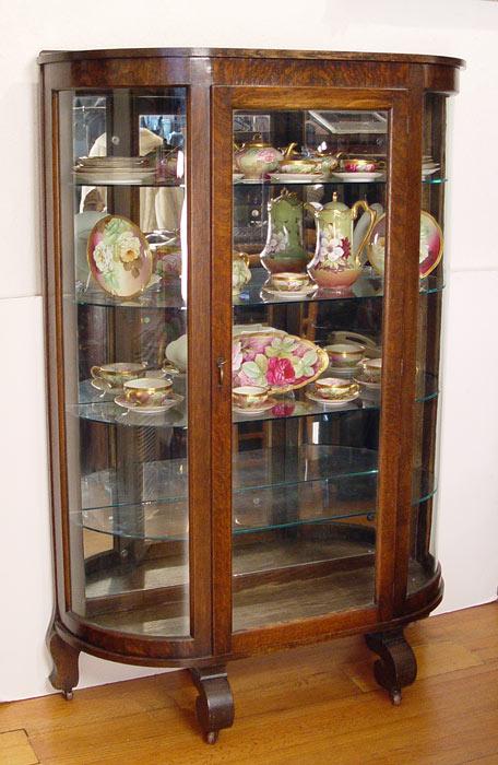 Appraisal: LATE VICTORIAN TIGER OAK BOW SIDE CHINA CABINET On scroll