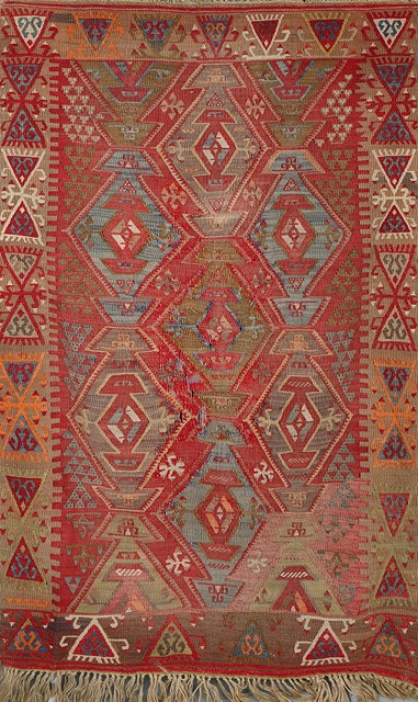 Appraisal: A TURKISH RED GROUND KELIM with polychrome medallion decoration within