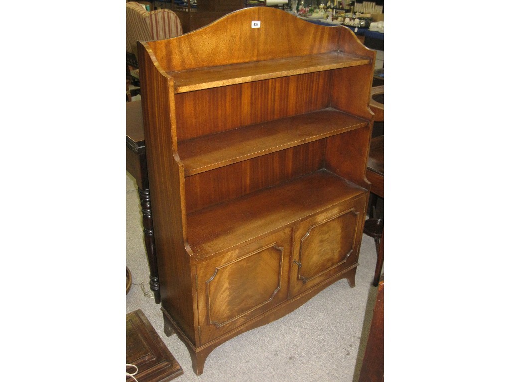 Appraisal: Reproduction mahogany waterfall bookcase with cupboard base