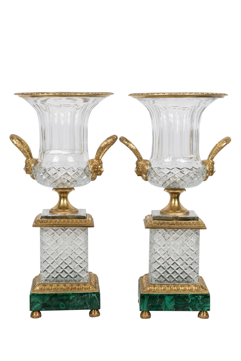 Appraisal: PAIR OF CUT-GLASS URNSwith gilt metal mounts on malachite-veneered bases