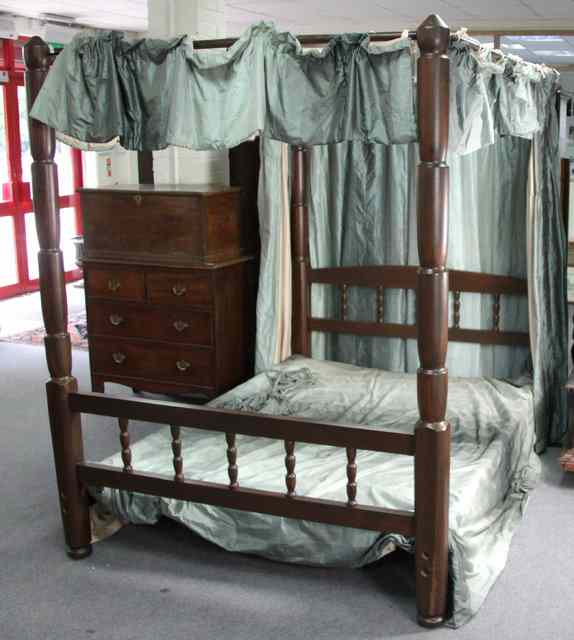 Appraisal: A stained pine four-poster bed with baluster uprights to the