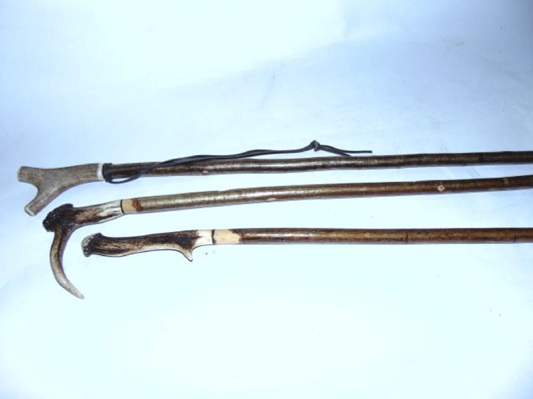 Appraisal: A trio of tall rustic walking hiking canes principally in