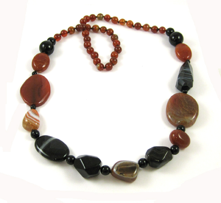 Appraisal: AGATE BEAD NECKLACE with carved and shaped black and amber