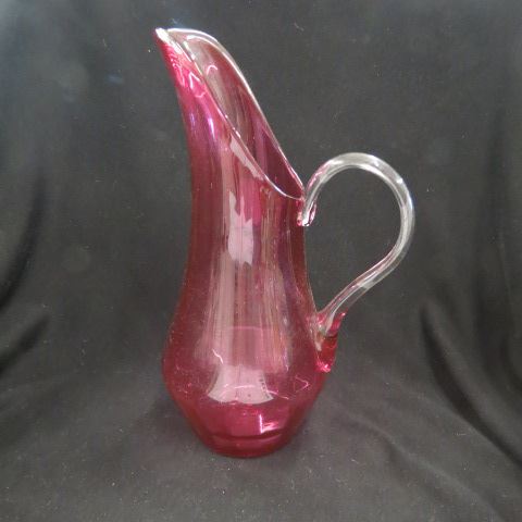 Appraisal: Cranberry Art Glass Pitcher ribbed body clear handle excellent