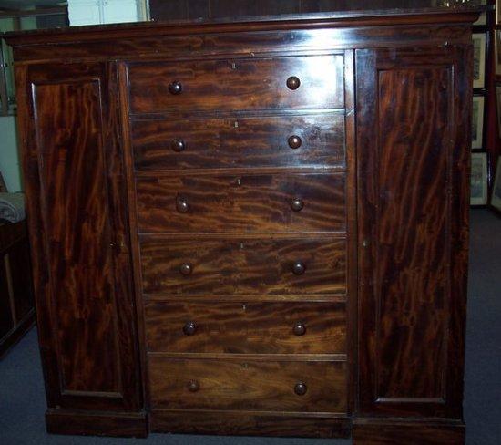 Appraisal: A Victorian mahogany compactum with cupboards flanking drawers on a