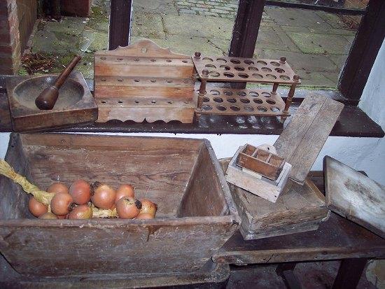 Appraisal: A treen pestle and square shaped mortar a spoon rack