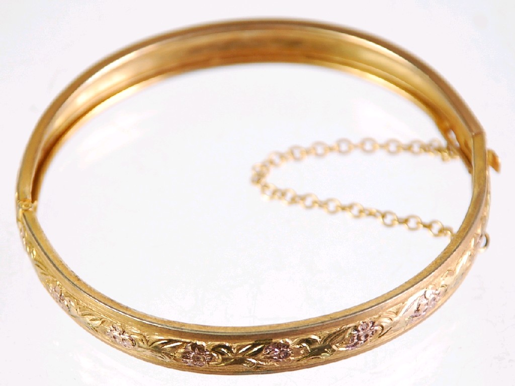 Appraisal: GOLD COLOURED FLORAL AND FOLIATE CHASED HINGE OPENING BANGLE approx