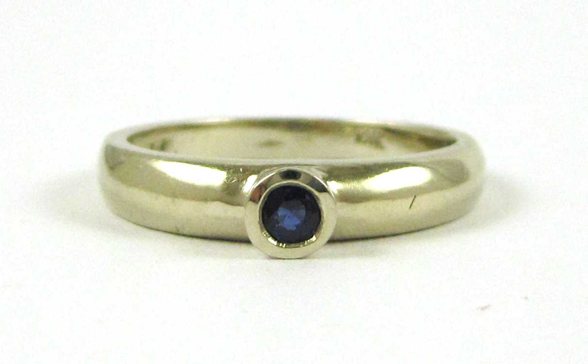 Appraisal: SAPPHIRE AND FOURTEEN KARAT GOLD SOLITAIRE RING bezel set with