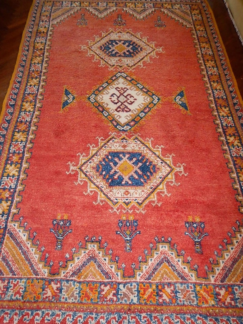 Appraisal: A Moroccan bordered rug with triple medallion centre on a