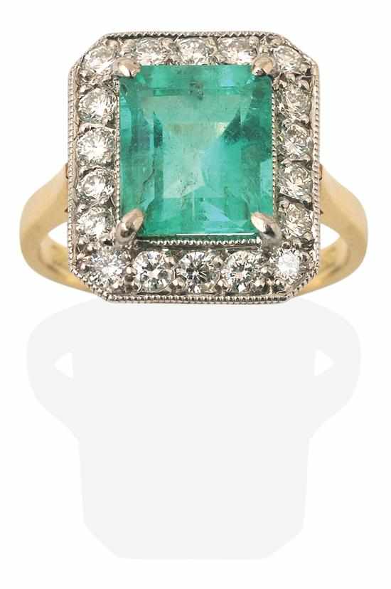 Appraisal: AN EMERALD AND DIAMOND RING Of cluster design centrally set