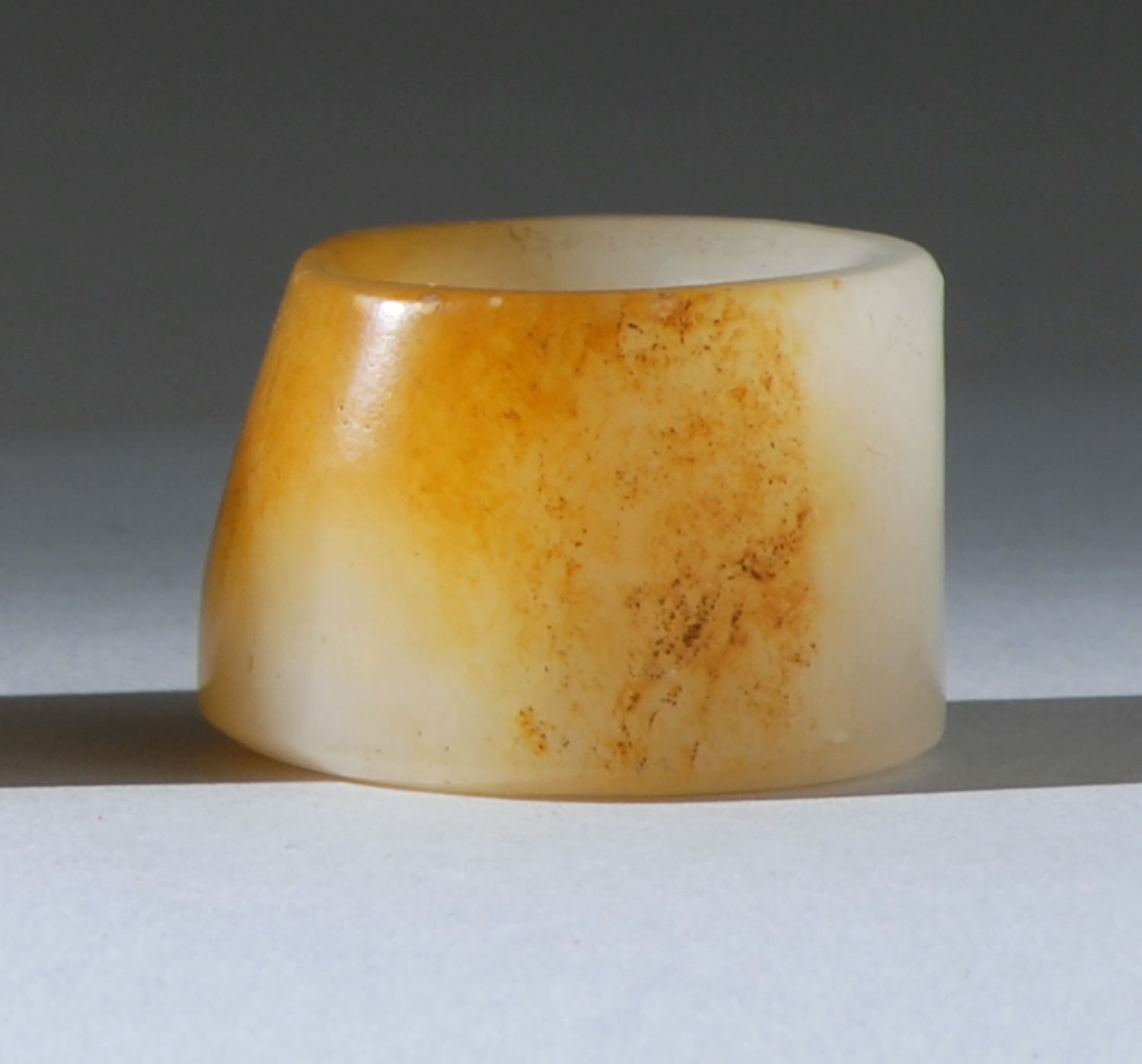 Appraisal: WHITE AND RUSSET JADE THUMB RING th CenturyWith some flattened