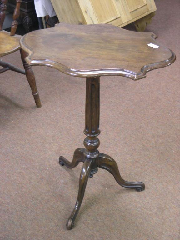 Appraisal: A Victorian mahogany occasional table serpentine shaped top on fluted