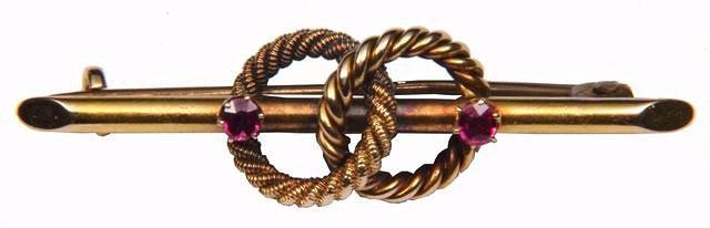 Appraisal: A RUBY SET BAR BROOCH with two interlocking rope twist