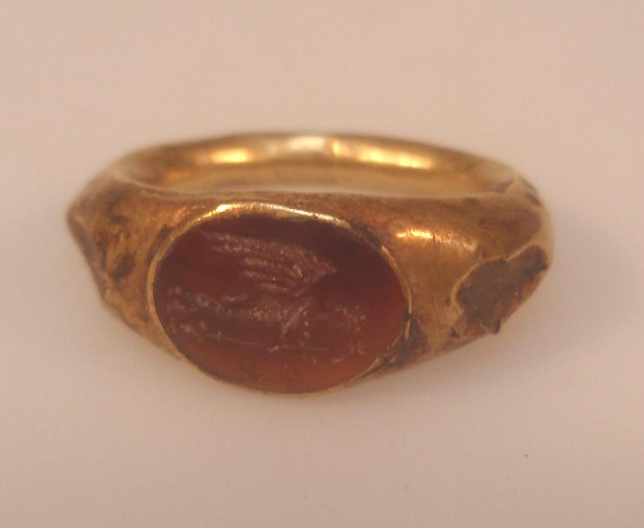 Appraisal: A Roman hollow gold ring set with an oval carnelian