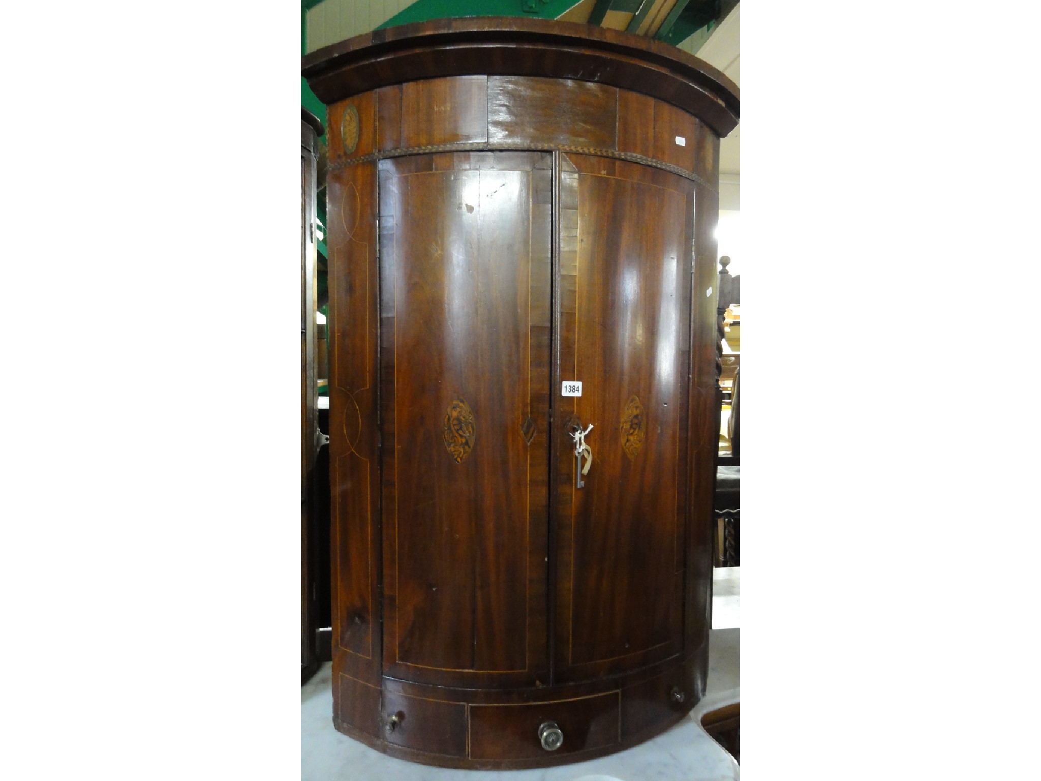 Appraisal: A Georgian mahogany bow fronted hanging corner cupboard fitted over