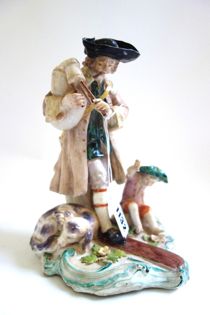 Appraisal: A Chelsea figure group circa modelled as a bagpiper standing