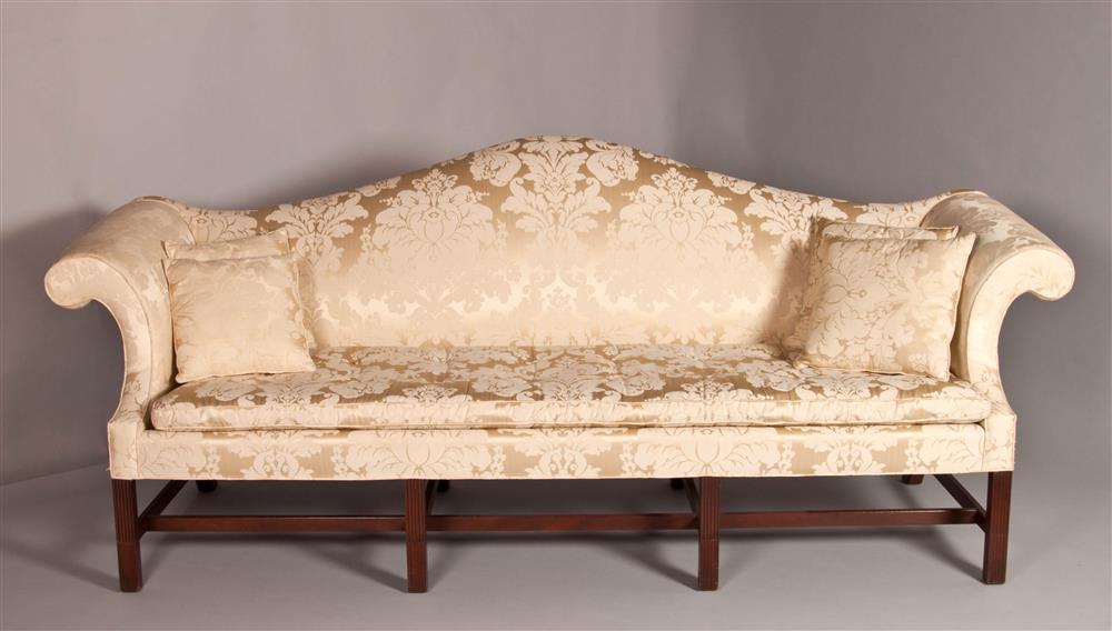 Appraisal: CHIPPENDALE STYLE CAMELBACK SOFA with an arching crest rail over