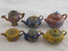 Appraisal: Five cloisonne enamelled miniature teapots and an unglazed ceramic example