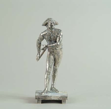 Appraisal: SILVER PLATED HARLEQUIN Standing man in costume holds sword behind