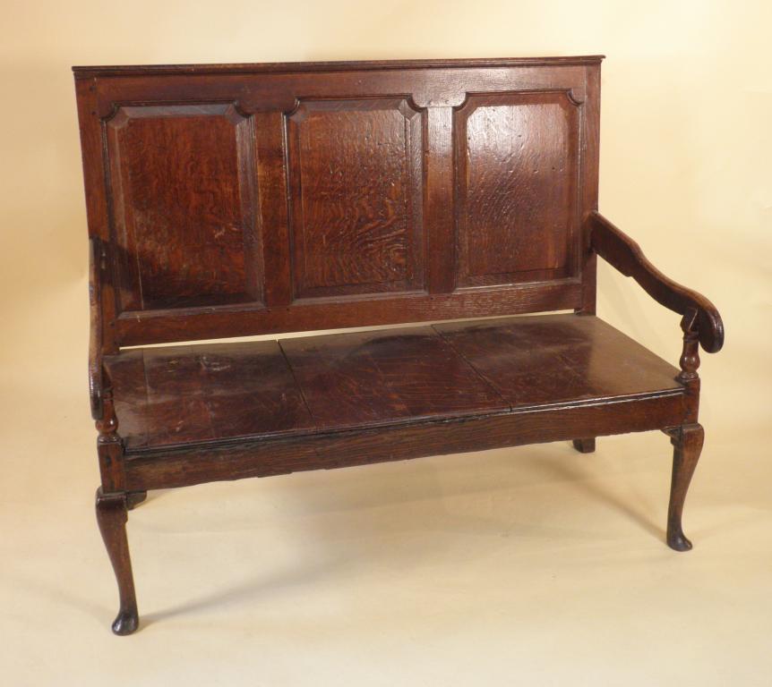 Appraisal: A George III oak settle with a panelled back solid