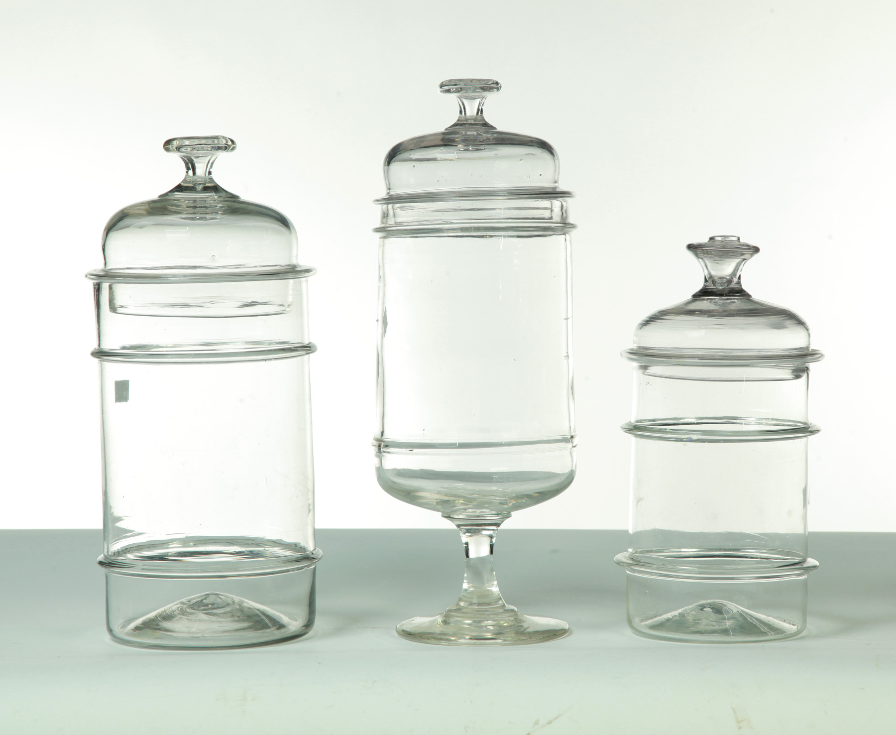 Appraisal: THREE BLOWN GLASS STORAGE JARS Pittsburgh mid- th century Applied