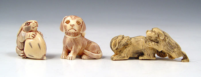 Appraisal: JAPANESE CARVED IVORY ANIMAL FIGURE NETSUKE To include dogs signed