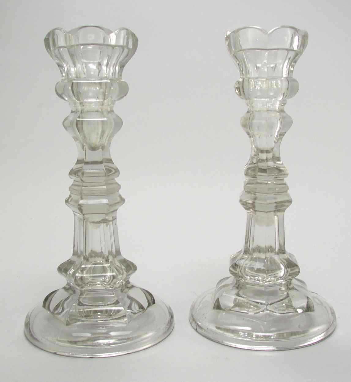 Appraisal: PAIR OF CLEAR PRESSED GLASS CANDLESTICKS Pittsburgh Circa In hexagonal