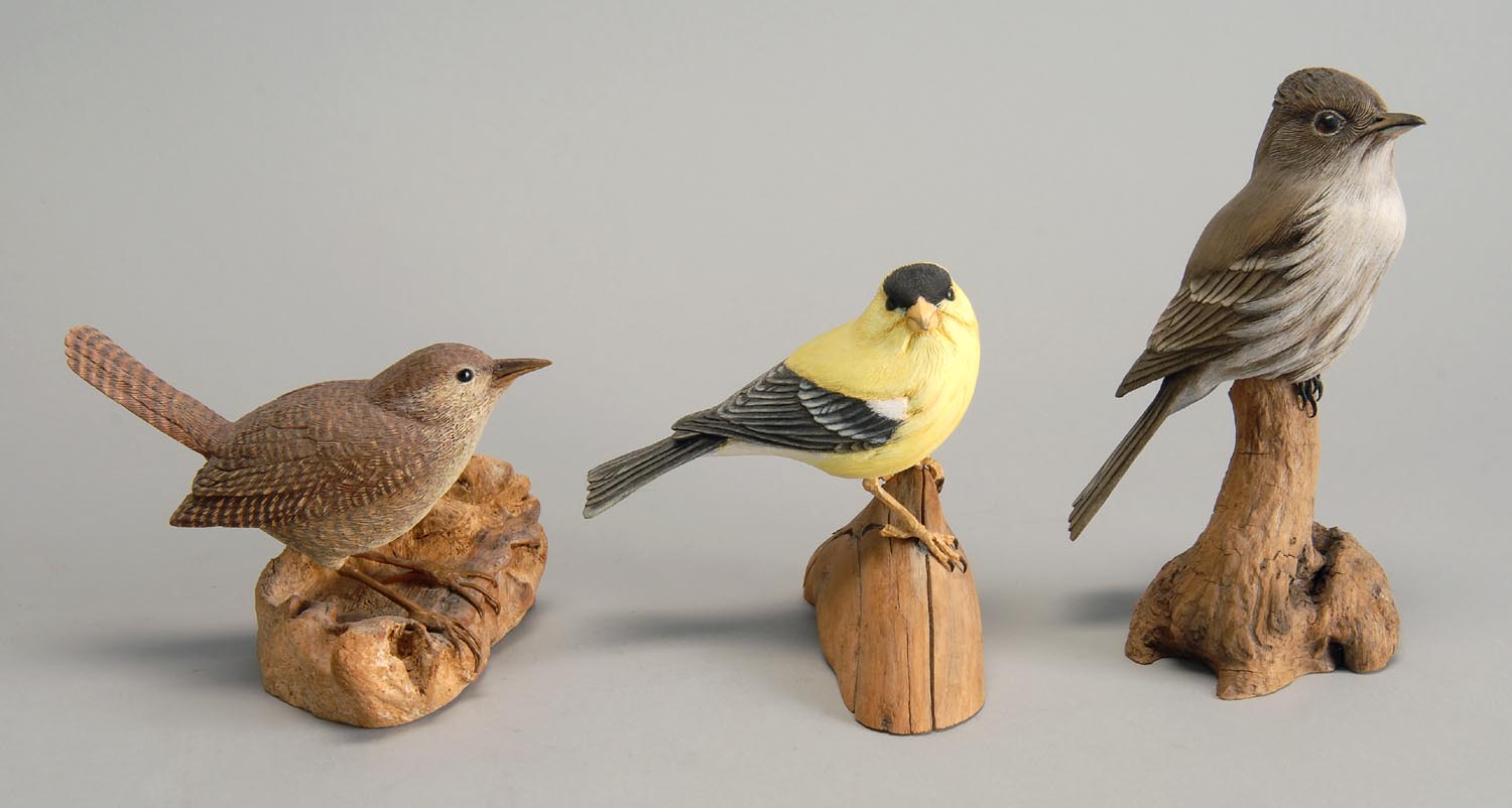 Appraisal: THREE DECORATIVE CARVED LIFE-SIZE SONGBIRDS a house wren by Robinson