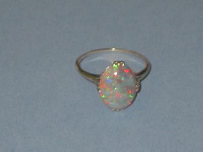 Appraisal: A BLACK OPAL RING the oval cabochon set with four