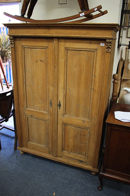 Appraisal: A CONTINENTAL PINE ARMOIRE the three of the panelled doors