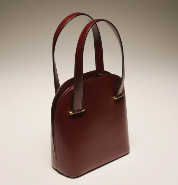 Appraisal: Cartier burgundy grain leather handbag brass hardware rounded zipper top