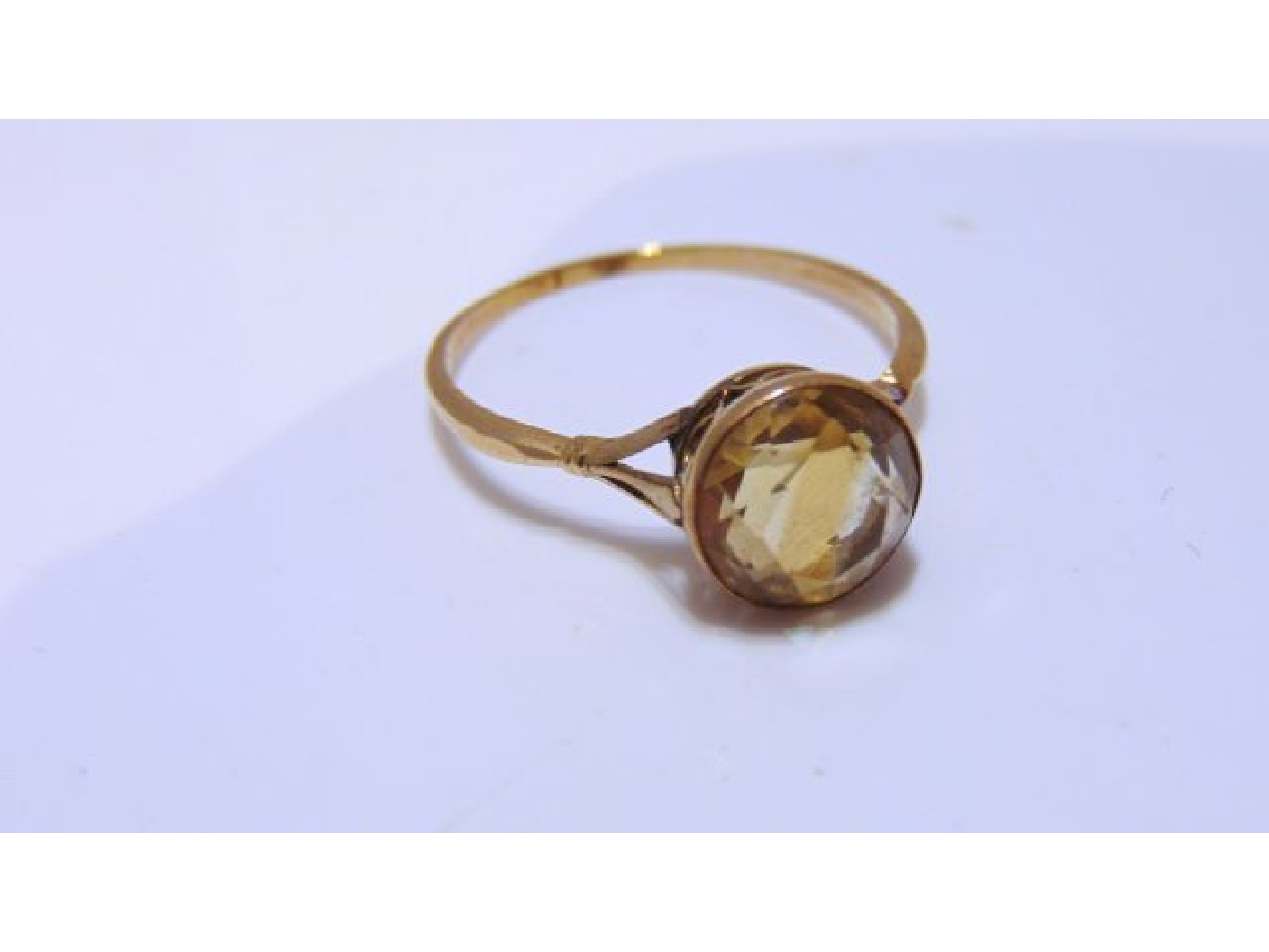 Appraisal: A citrine ring centred with a round mixed-cut untested citrine