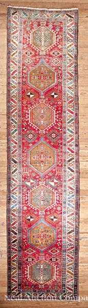 Appraisal: A Persian Heriz Runner crimson ground central geometric lozenge pattern