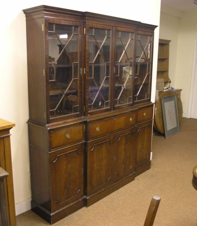 Appraisal: A reproduction mahogany breakfront secretaire bookcase upper stage enclosed by