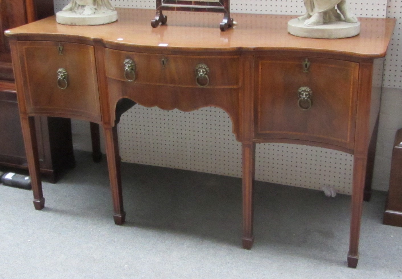 Appraisal: A George III inlaid mahogany sideboard the serpentine top over