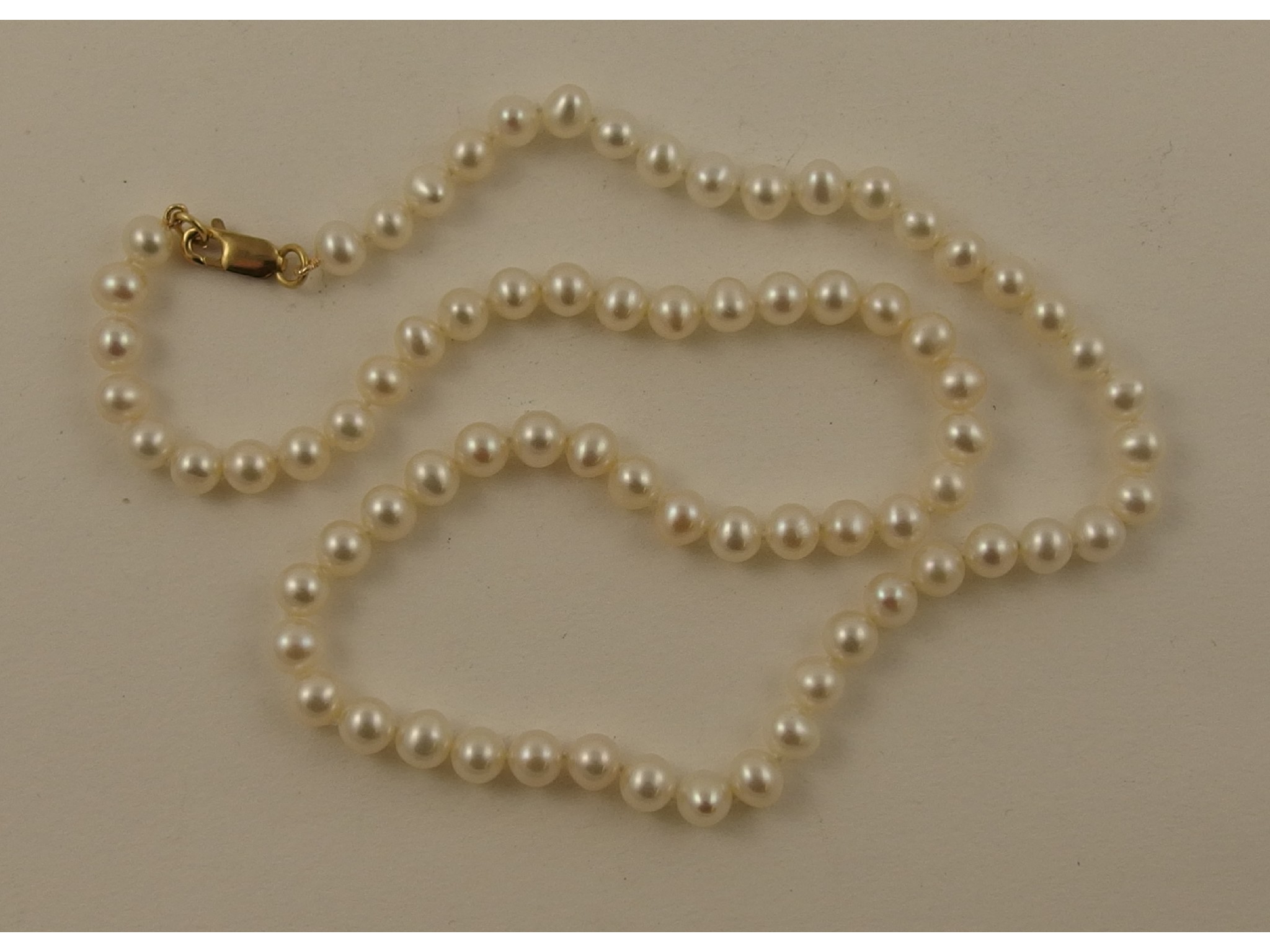 Appraisal: A string of white cultured pearls with a ct clasp