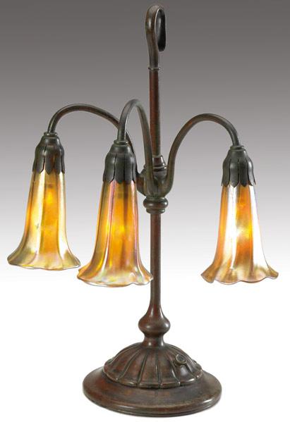 Appraisal: TIFFANY STUDIOS Three-light Lily lamp with a fluted base ending