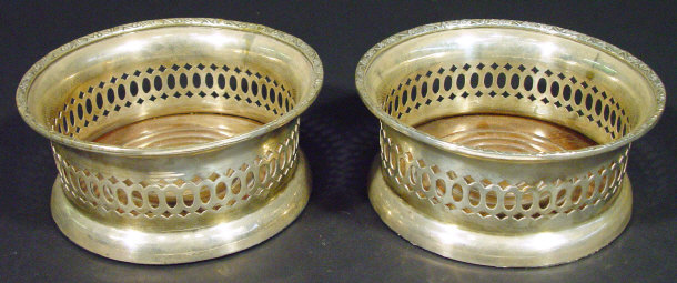 Appraisal: Pair of pierced silver plated wine coasters with mahogany bases