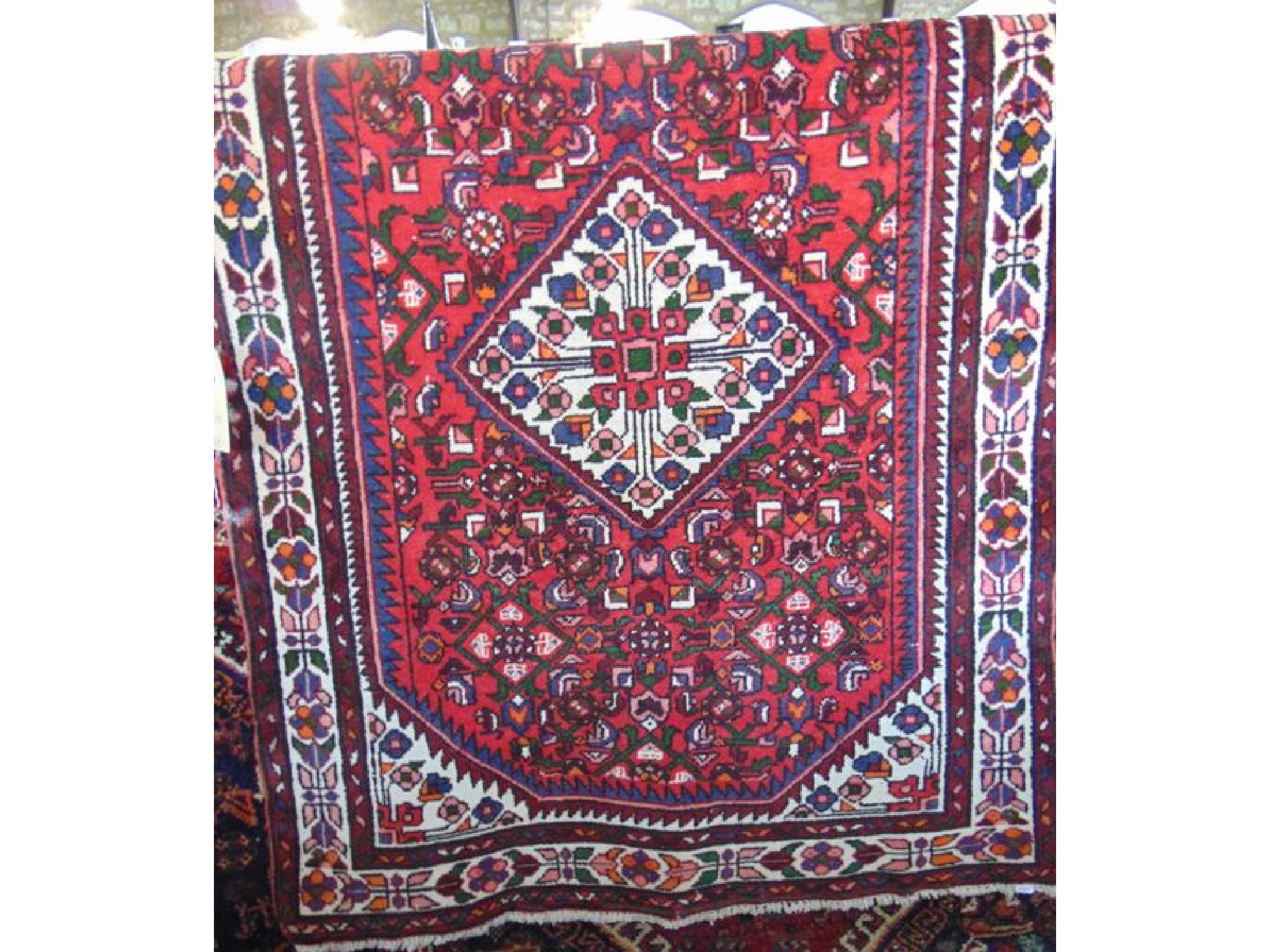 Appraisal: A Persian red ground wool rug with white ground central